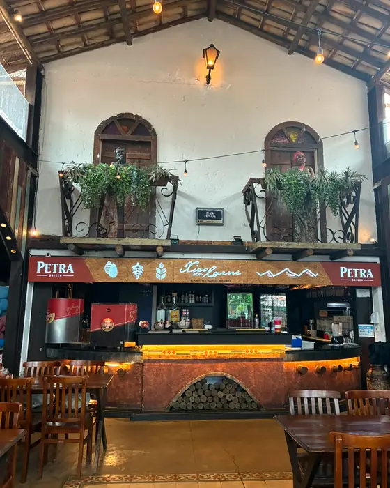 O bar da Cidade Nova com o letreiro do Xico e, em cima, duas janelas de madeira com sacadas de ferro e plantas
